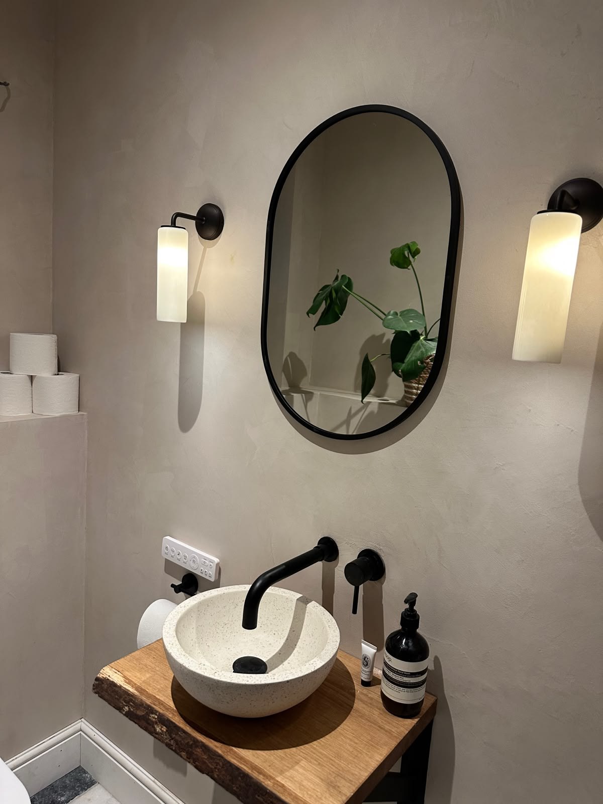 A bathroom with a Loxone Touch switch by the basin