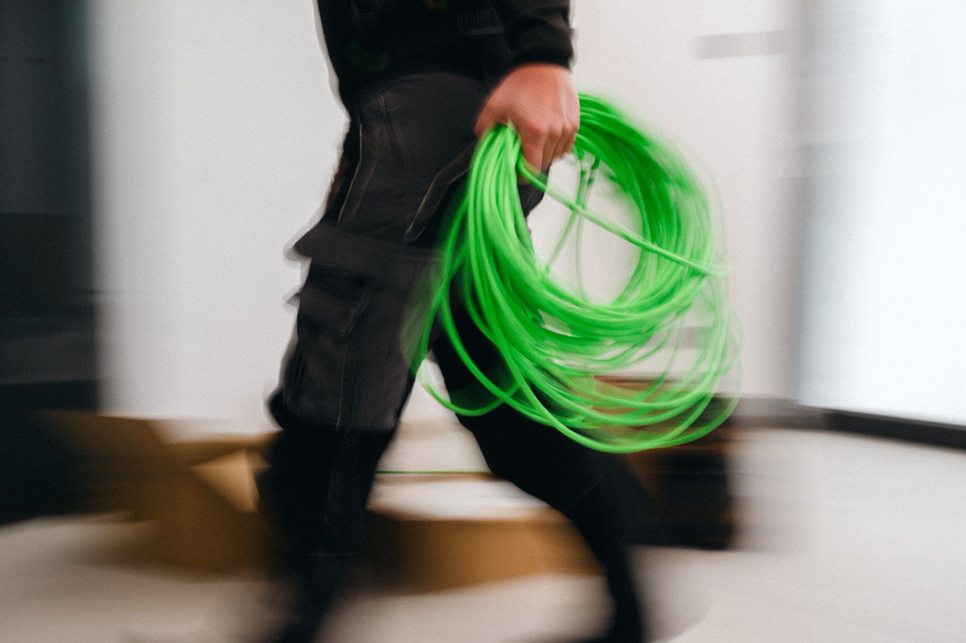An engineer carrying cable through a site